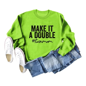 Flat lay of bright green sweatshirt featuring black Make It A Double letter print