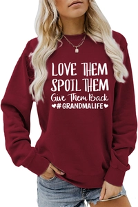 Gros plan sur l'inscription blanche LOVE THEM SPOIL THEM sur un sweatshirt bordeaux