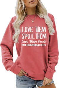 Gros plan d'un sweat rouge corail avec slogan LOVE THEM SPOIL THEM imprimé en blanc