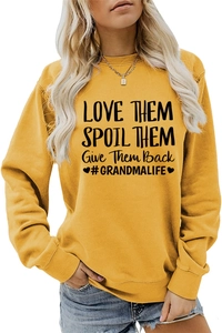 Détail du texte LOVE THEM SPOIL THEM sur un sweat à manches longues jaune gingembre