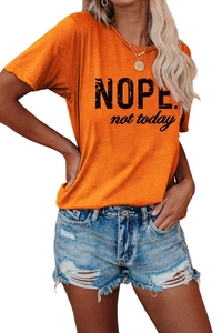 Détail du t-shirt orange avec lettrage Nope not today et short en jean délavé chic