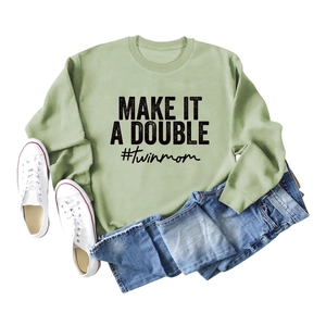 Flat lay of light green sweatshirt with Make It A Double and twinmom print