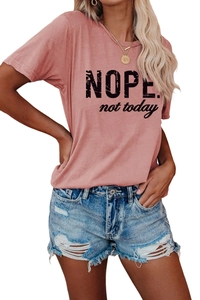 Gros plan détaillé de l'imprimé NOPE. not today sur un t-shirt rose à col rond