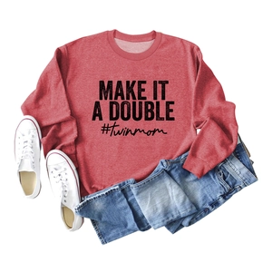Flat lay of red sweatshirt with Make It A Double text, styled with jeans and canvas shoes