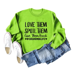 Mise à plat d'un sweat vert néon avec texte graphique noir et mini-short en jean