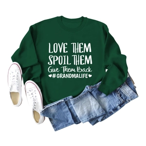 Mise à plat d'un sweat à col rond vert foncé avec slogan blanc et un jean bleu clair