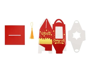 Flat lay of red graduation cupcake box components with gold lettering and yellow tassel