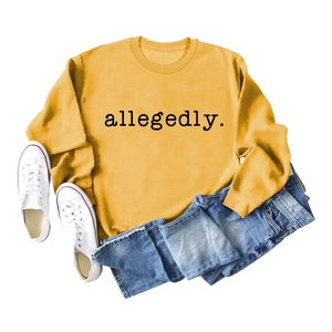 Mise à plat d'un sweat jaune moutarde avec texte allegedly, un jean et des baskets