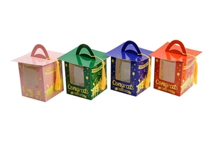 Detailed view of graduation muffin boxes with mortarboard lids and gold tassels in four colors