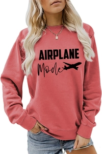 Détail de la texture en coton et de l'imprimé Airplane Mode sur le sweat-shirt rouge corail