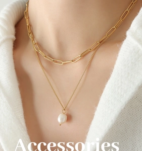 Détail d'un collier multicouche en titane doré avec pendentif perle sur un mannequin