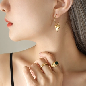 Boucles d'oreilles cœur dorées et bagues serties de gemmes vertes et cristaux