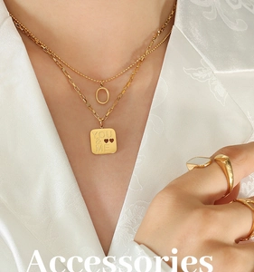 Detail of double-layer gold necklaces with heart motifs and You & Me engraving