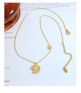 Détail du collier pendentif marguerite dorée avec zircon sur un livre artistique