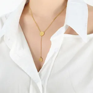 Collier double couche en or 18 carats avec pendentifs reine sur une chemise blanche
