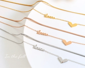 Detailed view of layered Love necklace with heart pendant in gold silver and rose gold