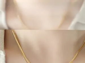 Close-up of double-layered gold necklace with flat snake chain and delicate link chain detail