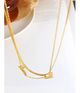 Close-up of golden double-layered necklace with Love script and heart charms