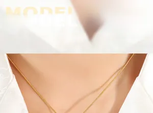 Detail shot of a golden snake chain necklace on model neck showing glossy finish and texture
