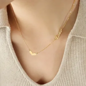 Golden heart necklace with Love engraving and cursive pendant on a female neck