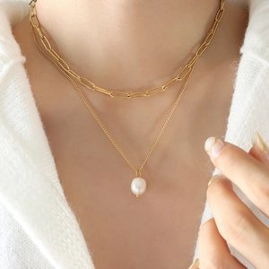 Collier double rang en chaîne trombone dorée avec pendentif perle blanche sur modèle