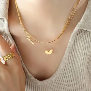 Double-layer gold heart necklace with Love charm and beaded ring on model
