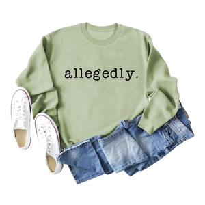 Mise à plat d'un sweat à col rond vert clair avec texte allegedly. et jean bleu