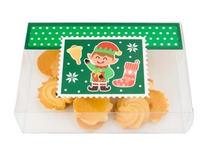 Macro view of transparent Christmas PVC gift box showing butter cookies and festive elf labels