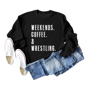 Detail of black crewneck sweatshirt with white WEEKENDS COFFEE WRESTLING slogan text