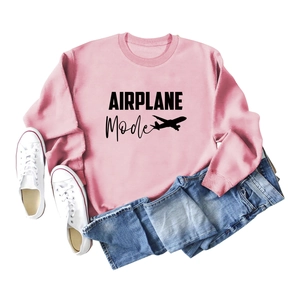 Détail du sweat-shirt rose à col rond avec texte Airplane Mode et motif d'avion noir