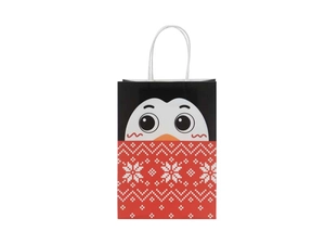 Close-up of a Christmas kraft gift bag featuring a cute penguin face and snowflake patterns
