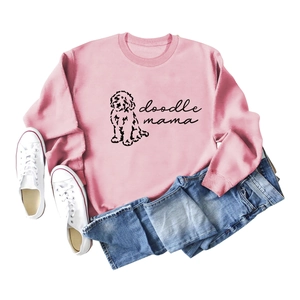 Sweat rose Doodle Mama avec motif chien, présenté à plat avec jean et baskets