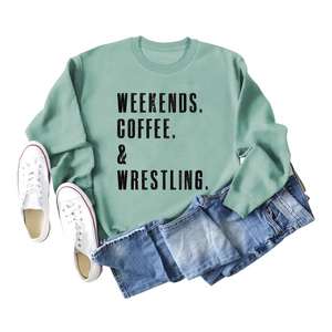Flat lay of mint green crewneck sweatshirt with black text print and styling props