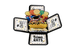 Macro detail of 3D pop-up graduation card with Grad and Congrats text and motifs