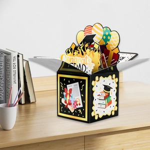 Detailed 3D pop-up graduation gift box featuring congrats grad balloons and academic icons