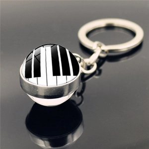 Gros plan d'un porte-clés piano en verre et métal argenté avec reflet sur fond noir élégant
