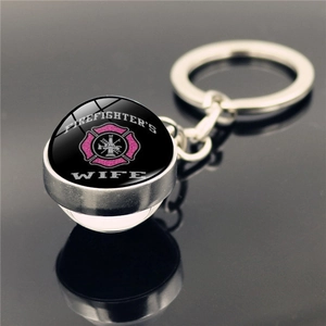 Detail of Firefighter's Wife round metal keychain with pink maltese cross under glass