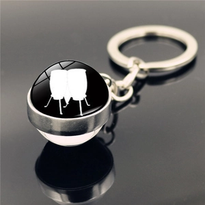 Détail macro du porte-clés en métal argenté avec illustration de conga sous verre
