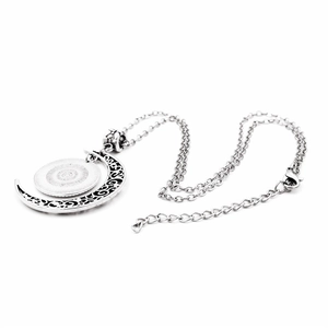 Detailed view of silver crescent moon necklace featuring a hollowed pattern and locket tray