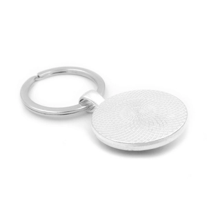 Silver sunflower glass gem keychain with textured metal backing on white background