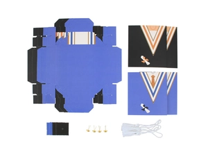 Flat lay of DIY graduation cap favor box kit with blue cardstock and silk tassels