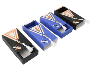 Detail of drawer-style graduation candy boxes with tassels and bachelor gown patterns