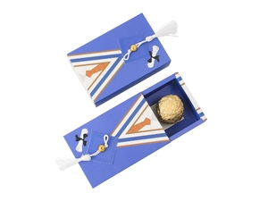 Close-up of graduation gown style favor boxes with blue tassels and chocolate inside
