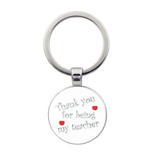 Detail of silver metal keychain with Thank you for being my teacher text and red apples
