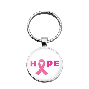 Macro detail of metal keychain with glass dome featuring pink ribbon Hope design