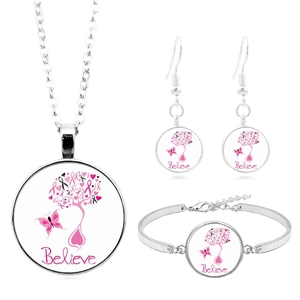 Détail du parure en argent avec pendentifs arbre ruban rose et lettrage Believe gravé
