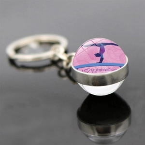 Artistic gymnastics glass ball keychain with pink gymnast silhouette on a black background