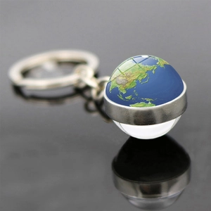 Vue macro du porte-clés globe terrestre en verre avec textures et anneau en métal argenté