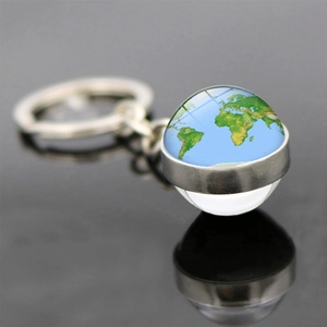 Porte-clés globe terrestre avec boule de verre et anneau en métal sur surface réfléchissante