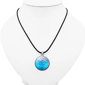 Detailed view of round dragon scale pendant with blue gradient texture on display